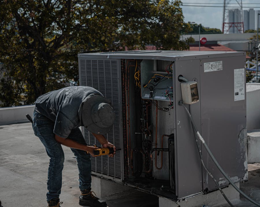 Professional HVAC technician servicing rooftop air conditioning unit in Tampa